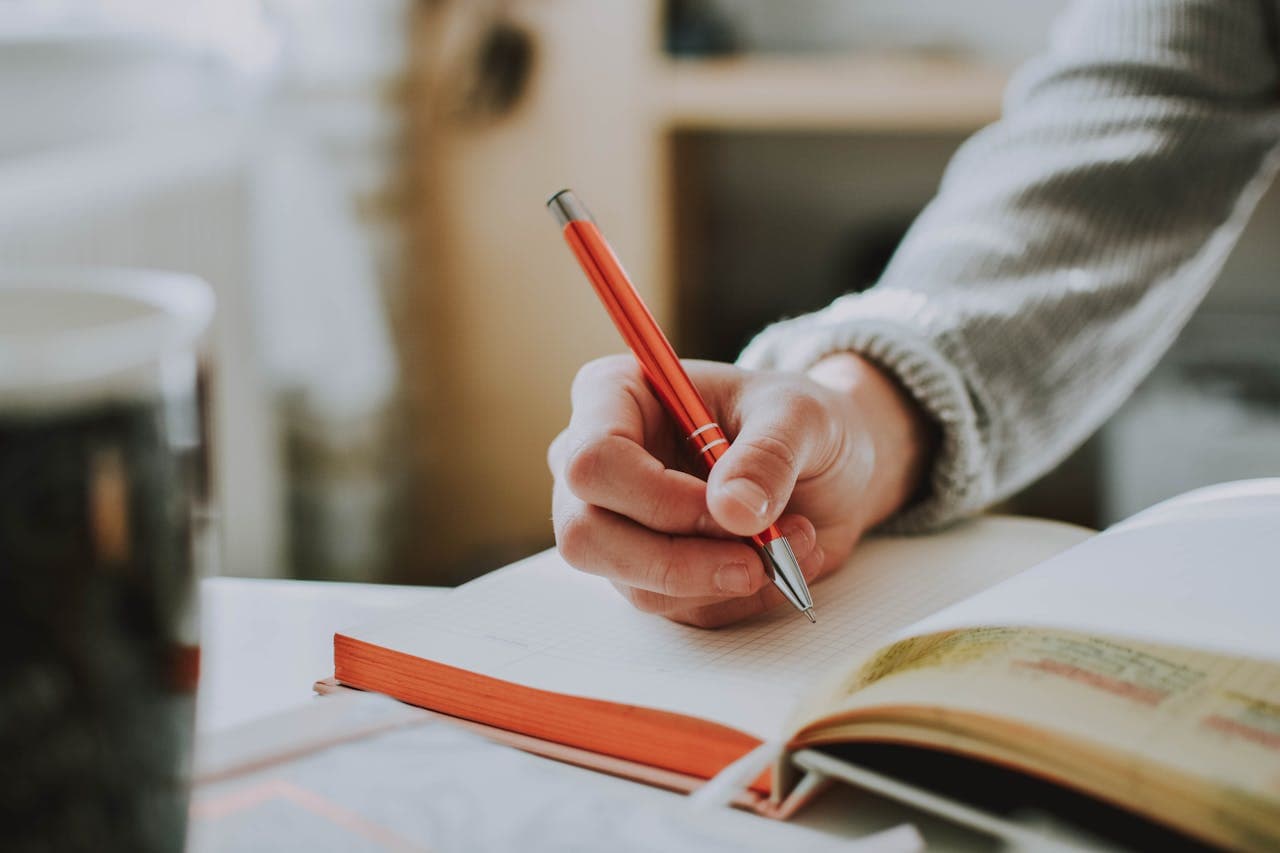 Person writing in a notebook while studying French for Express Entry in Canada