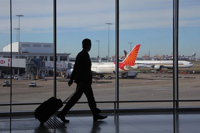 Traveler with luggage walking through an airport while waiting for a Canada PR application decision